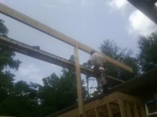 Carpenter setting a ridge beam over a new addition frame — Ice Dam Removal by Roofing Brothers in Tatums